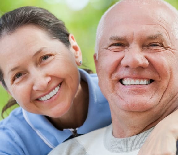 Older man and woman hugging and smiling