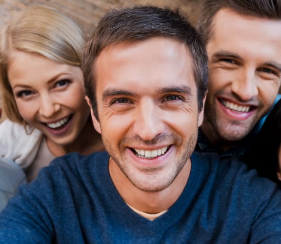 Group of people standing on a porch taking a selfie