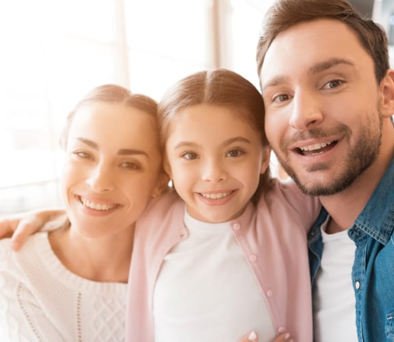 Family of three in their living room taking a selfie