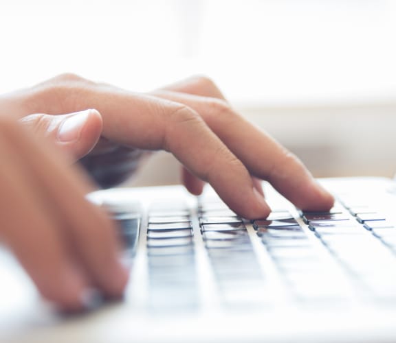 Hands typing on a laptop keyboard