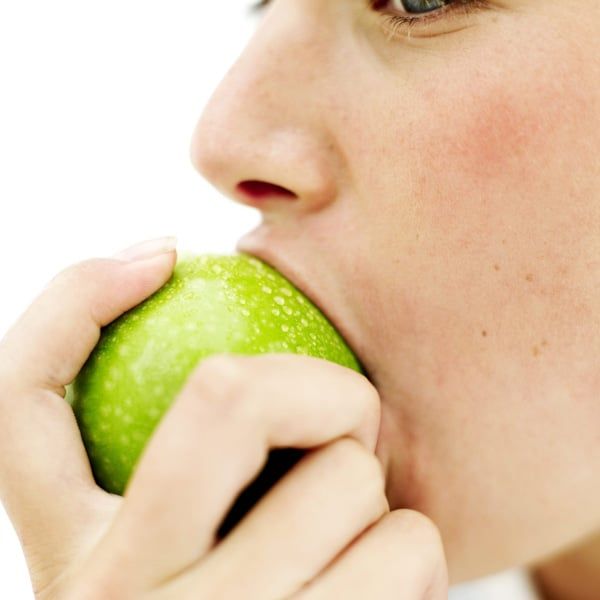 Woman eating a green apple